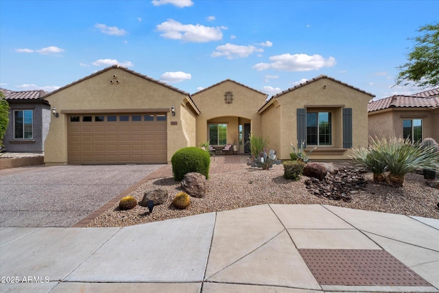 view of front facade featuring an attached garage, aphalt driveway, stucco siding, and a tile roof