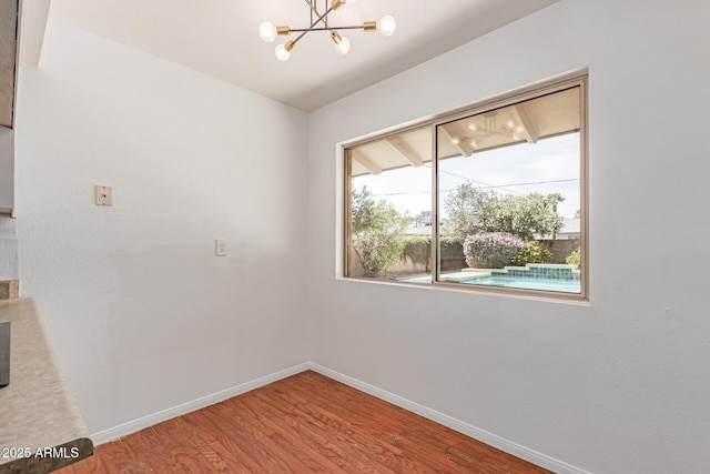 8738 E Vista Dr, Scottsdale, AZ 85250 - spare room with a chandelier and wood finished floors
