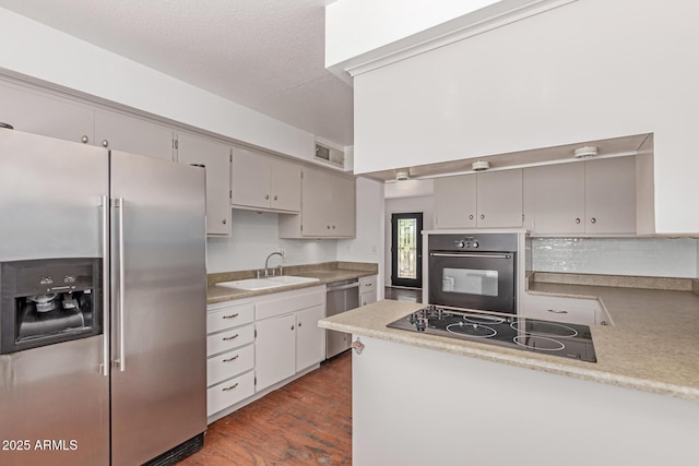 8738 E Vista Dr, Scottsdale, AZ 85250 - kitchen with black appliances, dark wood-style floors, backsplash, light countertops, and a peninsula