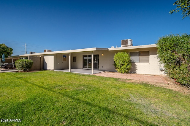 back of house featuring a lawn, central air condition unit, and a patio area