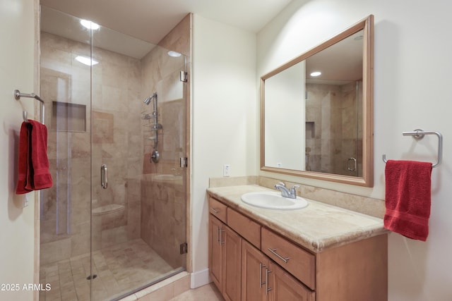 bathroom with an enclosed shower, vanity, and tile patterned flooring