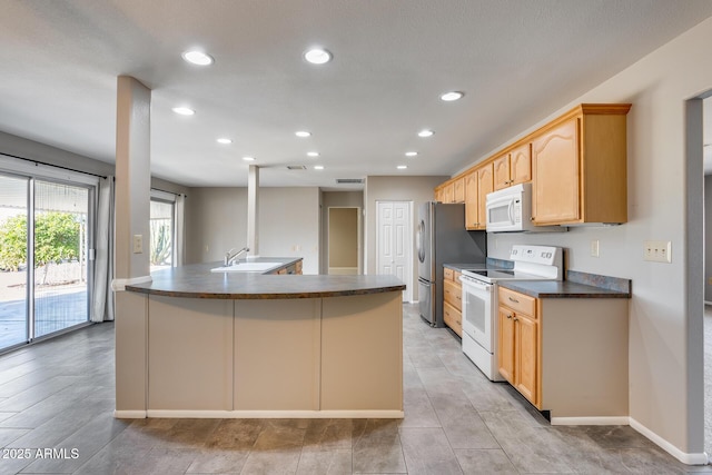 kitchen with sink, light brown cabinets, and white appliances