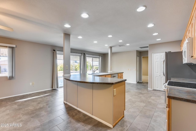 kitchen with appliances with stainless steel finishes, sink, and a kitchen island with sink