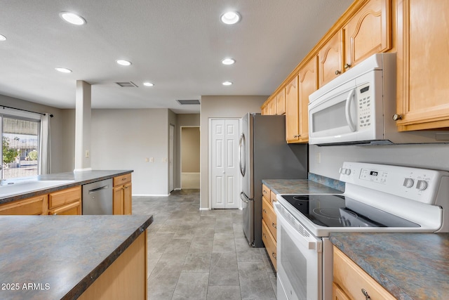 kitchen featuring sink, light brown cabinets, and white appliances