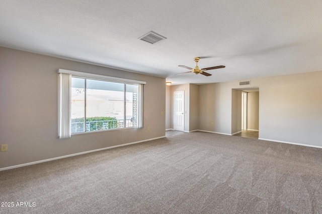 empty room with ceiling fan, carpet flooring, and a textured ceiling