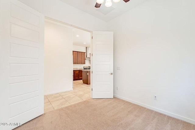 unfurnished room with light colored carpet, baseboards, lofted ceiling, and ceiling fan