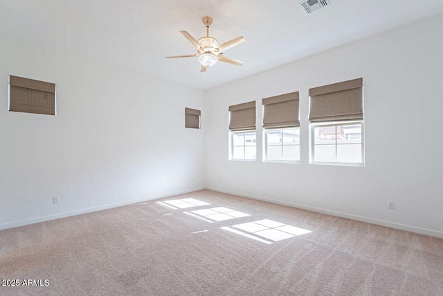 spare room with light carpet, baseboards, a ceiling fan, and visible vents