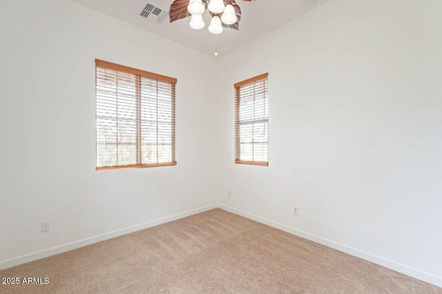 unfurnished room with baseboards, a ceiling fan, light colored carpet, and visible vents