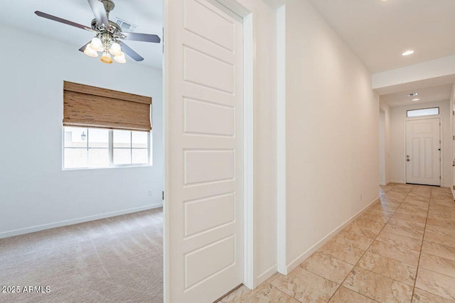 corridor featuring baseboards, recessed lighting, visible vents, and light carpet