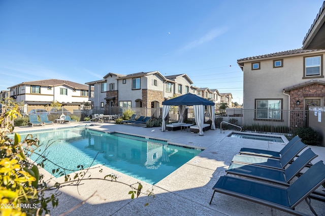 pool with a residential view, fence, and a patio