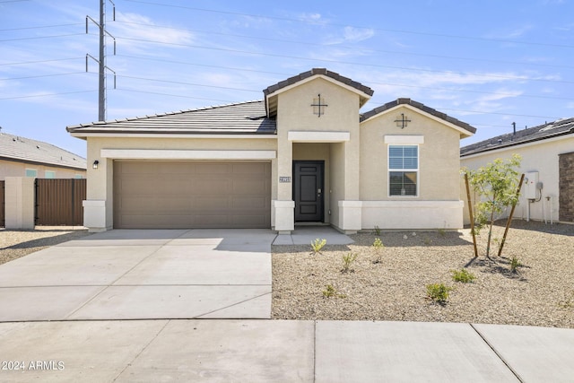 view of front facade with a garage, fence, concrete driveway, a tiled roof, and stucco siding