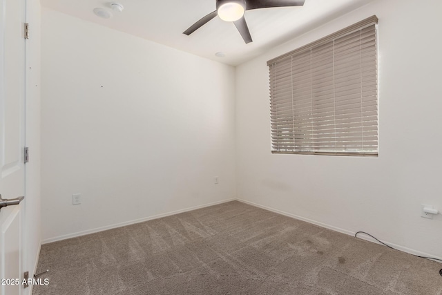 carpeted spare room with ceiling fan and baseboards