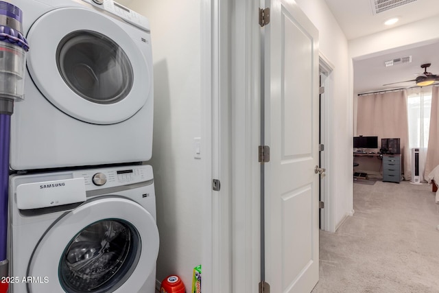 washroom with stacked washing machine and dryer and light carpet