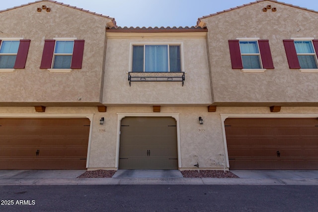 multi unit property featuring stucco siding and a garage