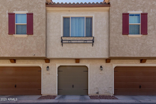 multi unit property with stucco siding and an attached garage