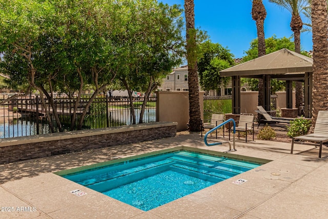 view of swimming pool with fence, a gazebo, a patio, and a water view