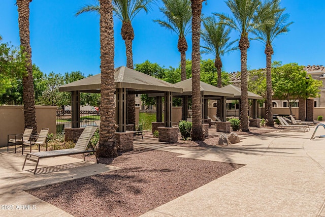 view of property's community featuring a gazebo, fence, and a patio