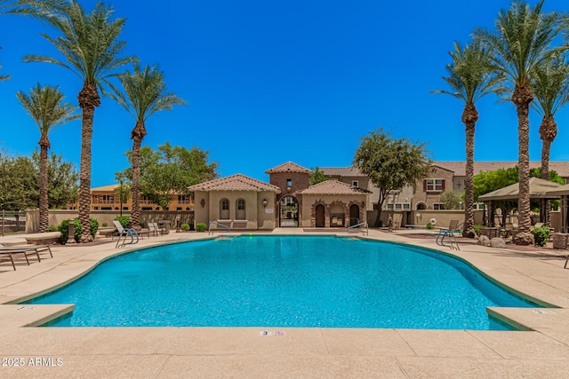 community pool with a gazebo, a patio, and fence