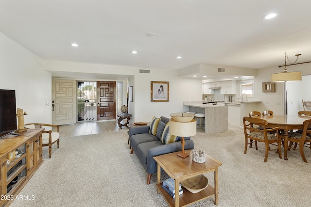 living area with light colored carpet, recessed lighting, and a wealth of natural light
