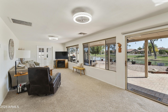 living room with french doors, carpet floors, a fireplace, and visible vents