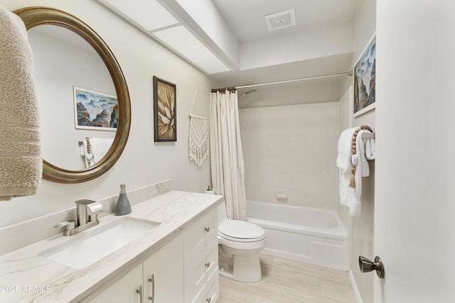 bathroom with shower / bath combo, visible vents, toilet, wood finished floors, and vanity