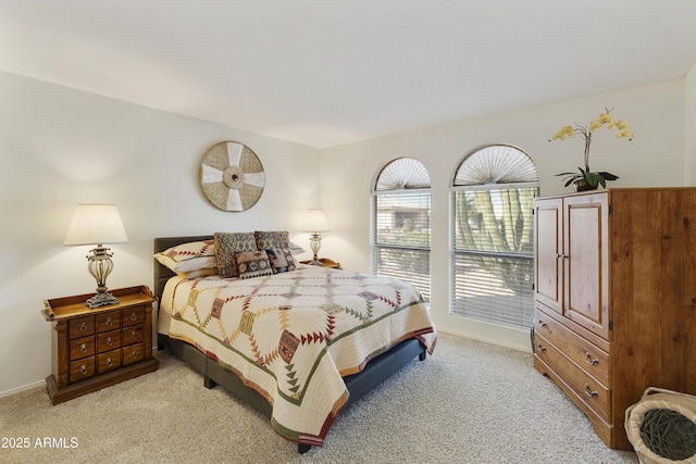 bedroom with light carpet and baseboards