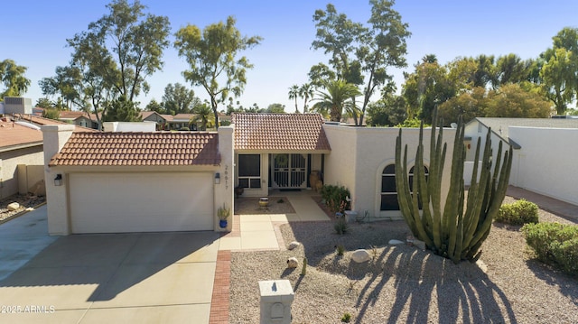 mediterranean / spanish-style home featuring central air condition unit, a garage, concrete driveway, a tile roof, and stucco siding