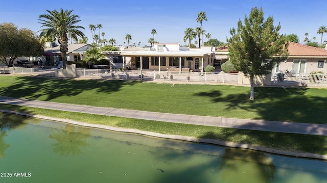 rear view of property featuring a fenced backyard, a water view, a patio area, and a yard