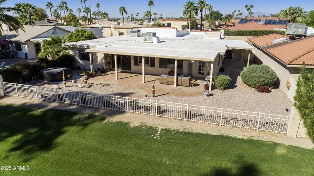 back of property with a patio, central AC, a fenced backyard, outdoor lounge area, and a lawn