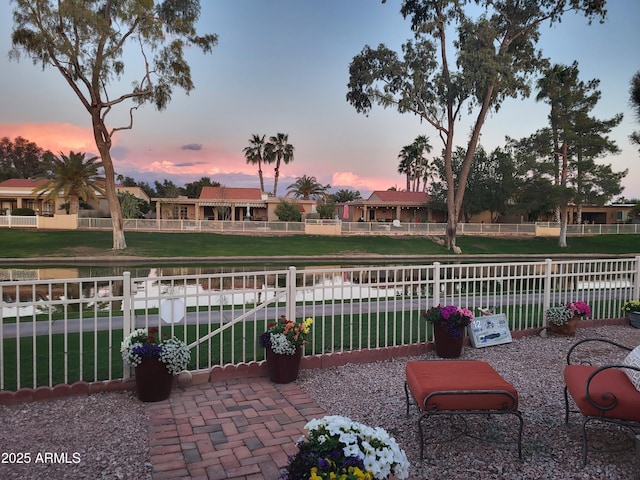 patio terrace at dusk with a lawn and fence