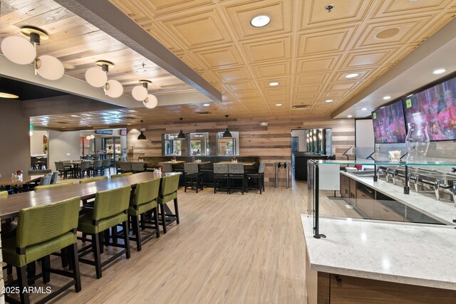 rec room with an ornate ceiling, wood walls, light wood finished floors, and recessed lighting