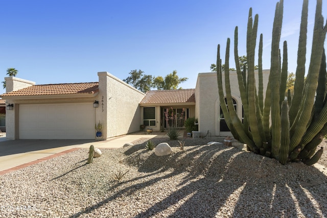 view of front of house featuring stucco siding, an attached garage, a tile roof, and concrete driveway