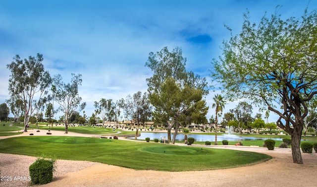 view of home's community with golf course view, a water view, and a lawn