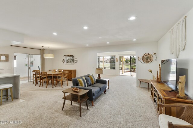 living area featuring recessed lighting and light colored carpet