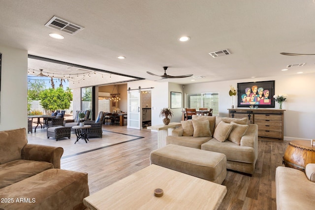 7510 E Larkspur Dr, Scottsdale, AZ 85260 - living room featuring a barn door, wood finished floors, recessed lighting, a ceiling fan, and baseboards