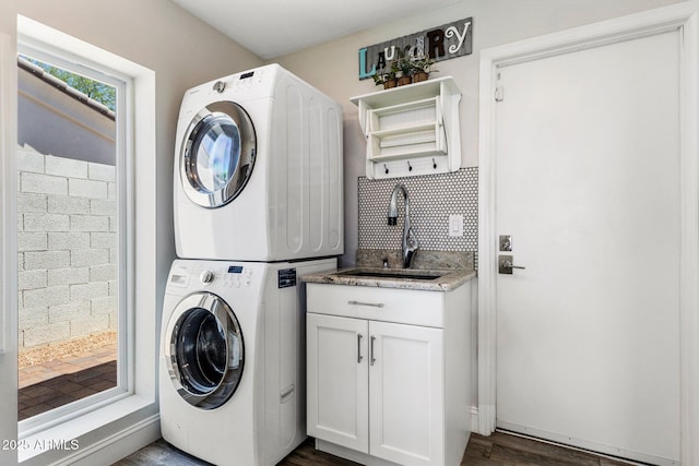 7510 E Larkspur Dr, Scottsdale, AZ 85260 - laundry area featuring stacked washer / dryer, cabinet space, and dark wood-style flooring
