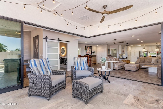 7510 E Larkspur Dr, Scottsdale, AZ 85260 - living area featuring ceiling fan, a barn door, a textured ceiling, and recessed lighting