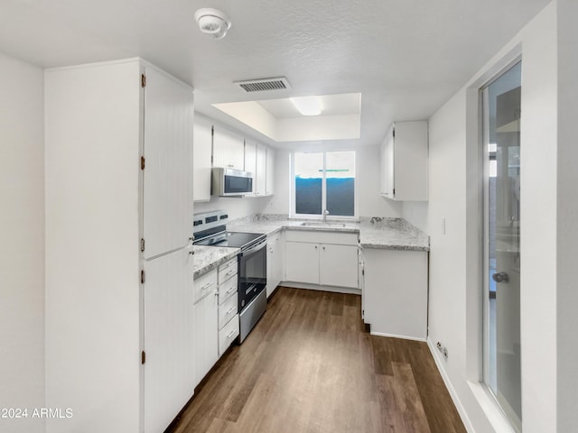 kitchen featuring a textured ceiling, stainless steel appliances, sink, wood-type flooring, and white cabinetry