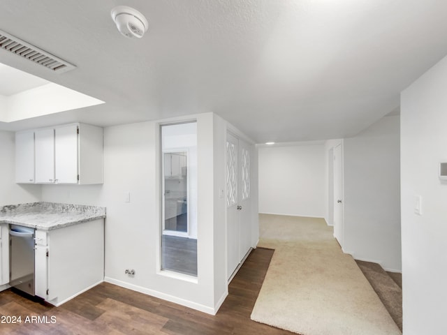 kitchen with dishwasher, dark hardwood / wood-style flooring, and white cabinetry