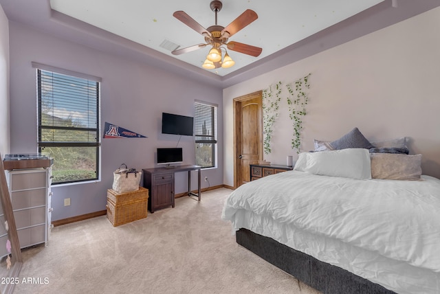 3217 N Piedra Cir, Mesa, AZ 85207 - bedroom with light colored carpet, baseboards, a tray ceiling, and a ceiling fan