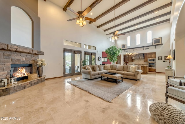 3217 N Piedra Cir, Mesa, AZ 85207 - living area featuring a ceiling fan, a high ceiling, beam ceiling, a stone fireplace, and baseboards