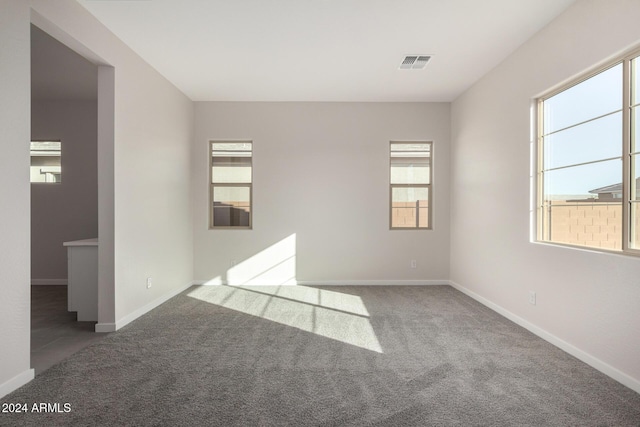 spare room featuring dark carpet