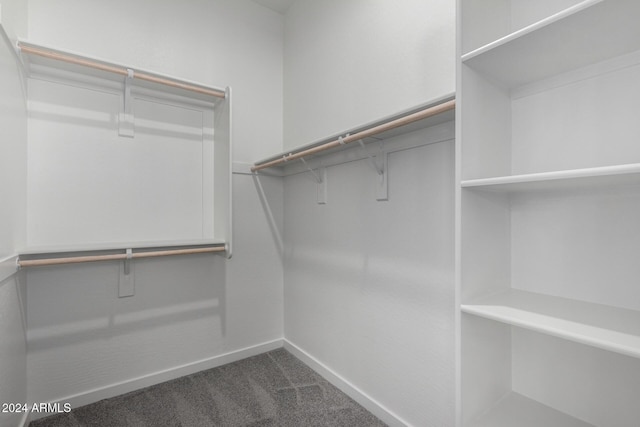 spacious closet featuring dark carpet