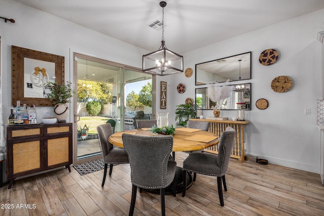 dining space with plenty of natural light, a chandelier, and light wood-type flooring