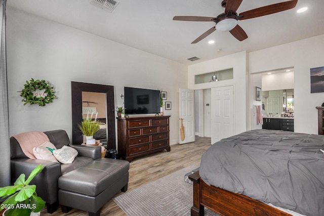 bedroom with ceiling fan, light wood-type flooring, and ensuite bath