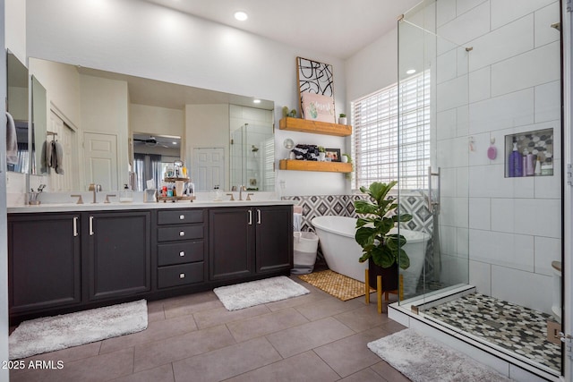 bathroom with independent shower and bath, tile walls, tile patterned flooring, vanity, and ceiling fan