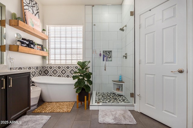 bathroom featuring independent shower and bath, vanity, tile walls, and tile patterned floors