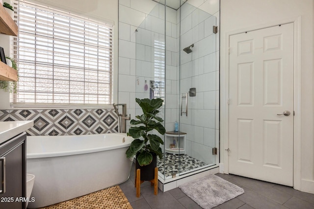 bathroom featuring tile patterned flooring, shower with separate bathtub, tile walls, and vanity