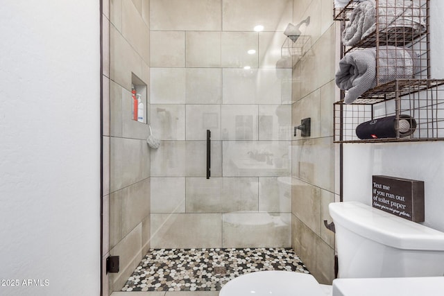 bathroom with toilet and a shower with shower door