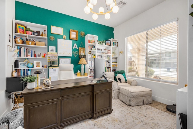 office space featuring an inviting chandelier and light hardwood / wood-style flooring